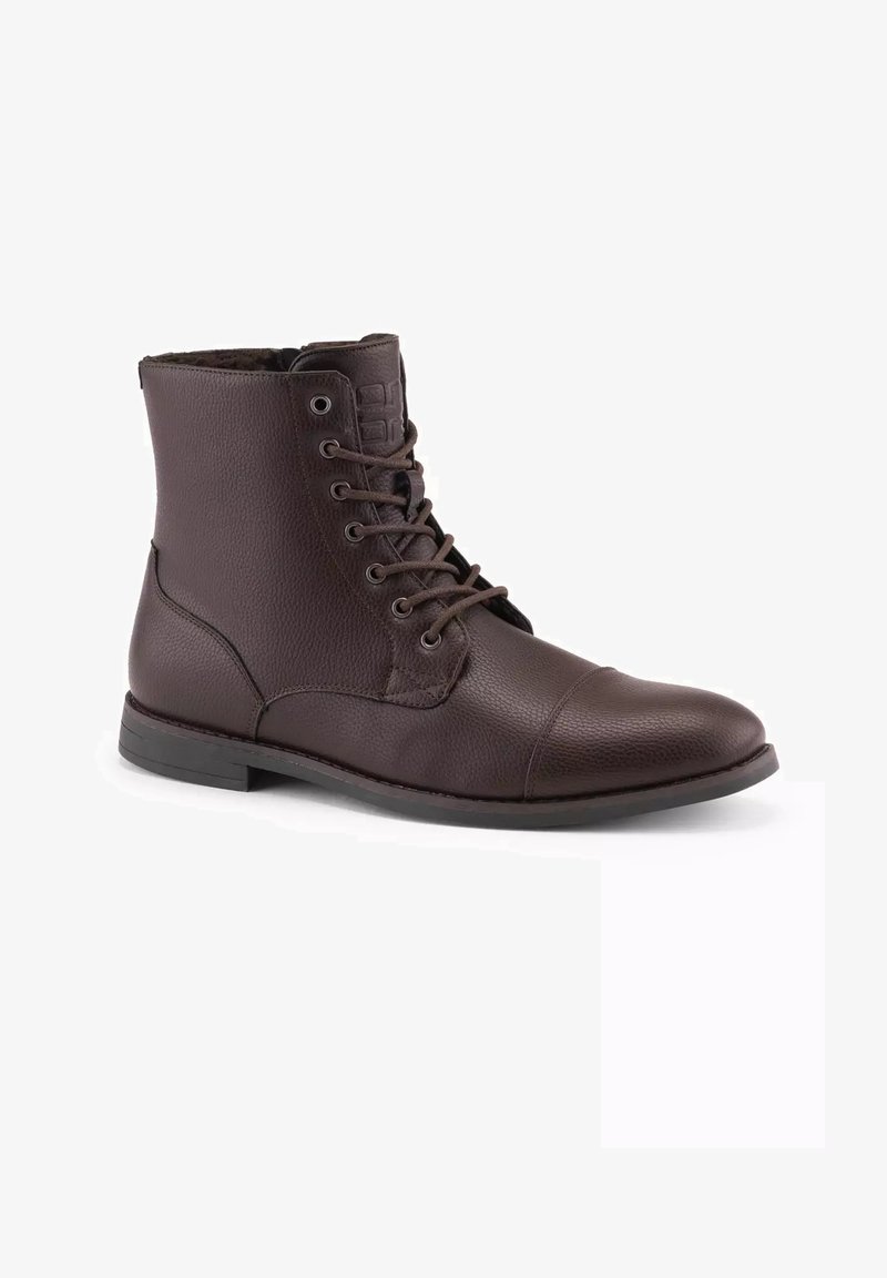 Bruna läderankelstövlar med en texturerad yta, snörning framtill, rund tå och låg klack. Innehåller diskret logotyp på tungan.