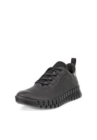 Sort lavtliggende læder-sneaker med tekstureret overflade, snørelukning og tyk rilleret sål, vist i en svag vinkel på hvid baggrund.