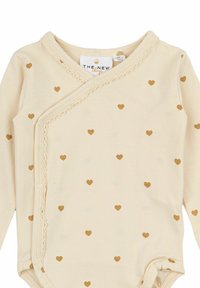 Långärmad babybodysuit i krämfärgad bomull med guldhjärtan, med en inslagningdesign, spetsdetaljer och tryckknappar i botten.