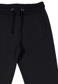 Pantaloni da tuta neri con una vita a coste, coulisse regolabile e tasche laterali, realizzati in un tessuto morbido ed elasticizzato.