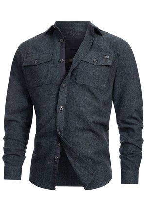 Camisa de franela azul oscuro para hombre con un cierre de botones en la parte delantera, dos bolsillos en el pecho y un cuello interior en contraste. Tejido texturizado con un patrón sutil.
