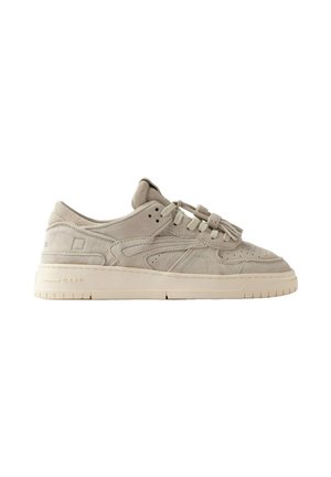 Sneakers beige chiaro in suede basse con chiusura frontale con lacci, dettagli traforati e suola spessa in gomma su sfondo bianco.