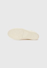 Gummisåle i off-white farge med et strukturert mønster som viser geometriske former og rygger for grep og fleksibilitet.