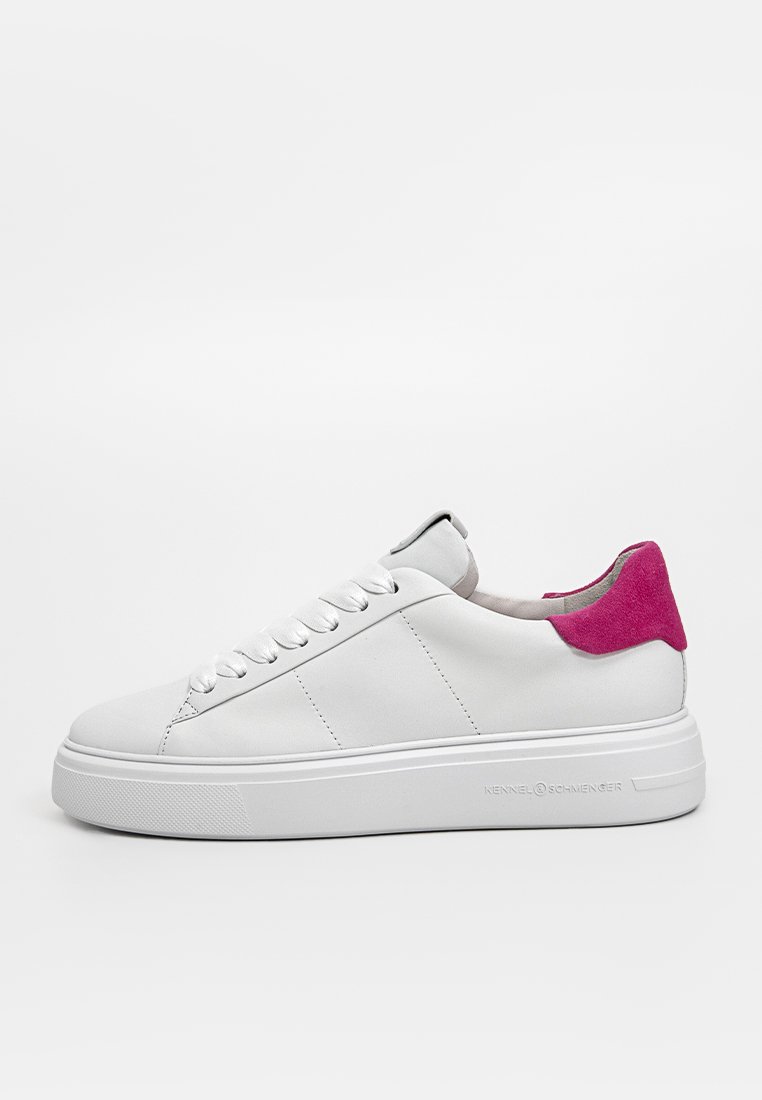 Basket en cuir blanc avec un accent de talon en suédine rose, semelle plate et rembourrée, et fermeture à lacets traditionnelle. Présente trois rayures sur le côté.