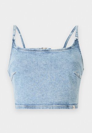 Un crop top en denim bleu clair avec des fines bretelles réglables, présentant une fermeture éclair à l'avant et une texture lisse, conçu pour un look ajusté.