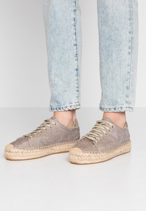 Teksturowane szaro-brązowe sneakersy z płótna z beżowymi sznurowadłami i podeszwą ze sznurka jutowego. Charakteryzują się metalicznymi akcentami i zaokrąglonym noskiem.