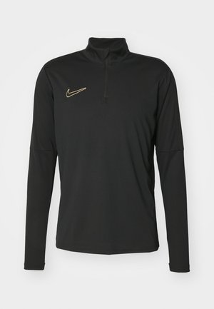 Pullover nero a maniche lunghe con collare a zip a quarti, caratterizzato da un logo Nike dorato sul petto. Realizzato in un tessuto liscio ed elastico.