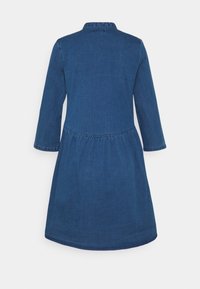 Denimmekko, jossa on tiukka bodice ja leveä helma, pitkät hihat ja kauluksellinen kaula-aukko. Syvä sininen väri ja sileä pinta.