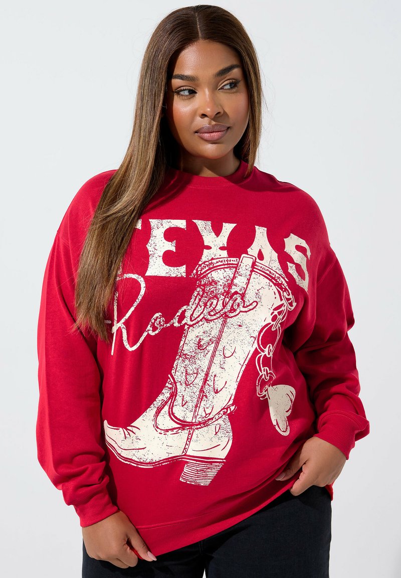 Sudadera roja con un gráfico de bota vaquera blanca y texto "Texas Rodeo". Hecha de tela suave con un ajuste relajado y puños acanalados.