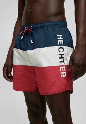 Maillots de bain pour hommes avec un design en blocs de couleurs bleu, blanc et rouge. Comprend une taille élastique avec cordon de serrage et une impression de logo sur le côté.