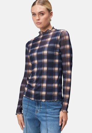 Durchsichtige Langarmbluse mit kariertem Muster in Marineblau und Beige, gewelltem Ausschnitt und gerafftem Seitendetail, kombiniert mit Jeans.