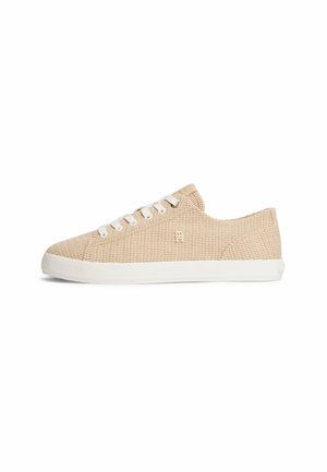 Beige lavtop sneaker med vævet tekstur, hvide snørebånd, hvid sål og gyldent metal-logo på siden, vist fra ydersiden.