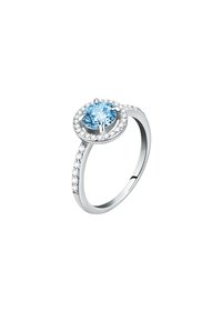 Anello in argento con una gemma blu rotonda in una montatura circolare, circondata da piccoli pietre trasparenti sulla fascia, che mette in risalto una finitura lucida.