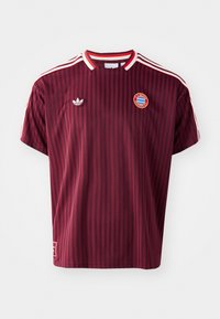 Maglia sportiva bordeaux con righe verticali, collo rotondo, accenti rossi, logo Adidas e stemma del Bayern Monaco. Maniche corte, materiale in cotone.