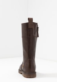 Brązowy skórzany botek za kostkę o gładkim wykończeniu, z bocznym zamkiem i teksturowaną tylną częścią. Posiada detal z logo oraz solidną gumową podeszwę.