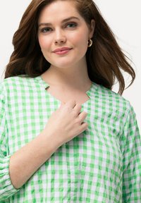 Grüne und weiße Gingham-Karo-Bluse mit entspannter Passform, runder Halsausschnitt, Dreiviertelärmel und subtiler Textur.