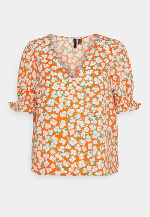 Blusa floral em laranja, com mangas curtas e bufantes e decote em V. Com padrão de pequenas flores brancas e rosas, com acentos verdes.