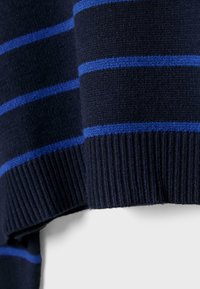 Maglione a righe blu navy con strisce orizzontali blu. Polsini e orlo a coste aggiungono texture. Il materiale sembra morbido e lavorato a maglia.
