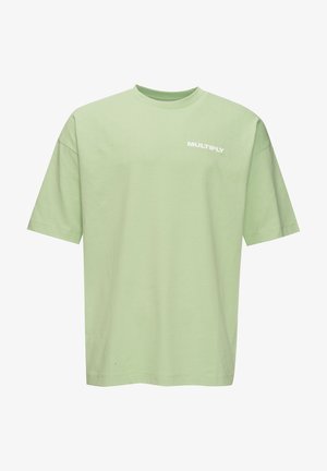 T-shirt vert clair à manches courtes et col rond avec le texte blanc "MULTIPLY" sur la partie supérieure gauche de la poitrine.