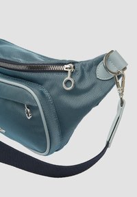Blauwe textuuroverhemd heupzak met een zilveren rits, verstelbare marineblauwe band en een voorvak. Heeft afgeronde hoeken en contrasterende accenten.