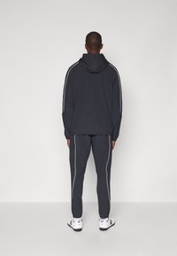 Under Armour CHALLENGER WARM UP  - Tracksuit bottoms - black/white