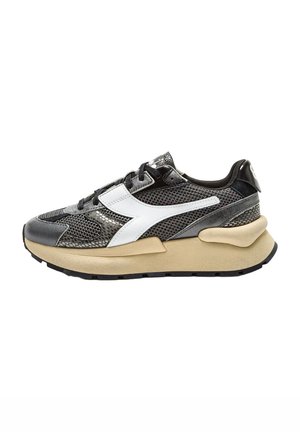Sneaker atletica in bianco e nero con tessuto in rete e accenti metallici. Suola chunky beige, pannelli a contrasto e finitura testurizzata.