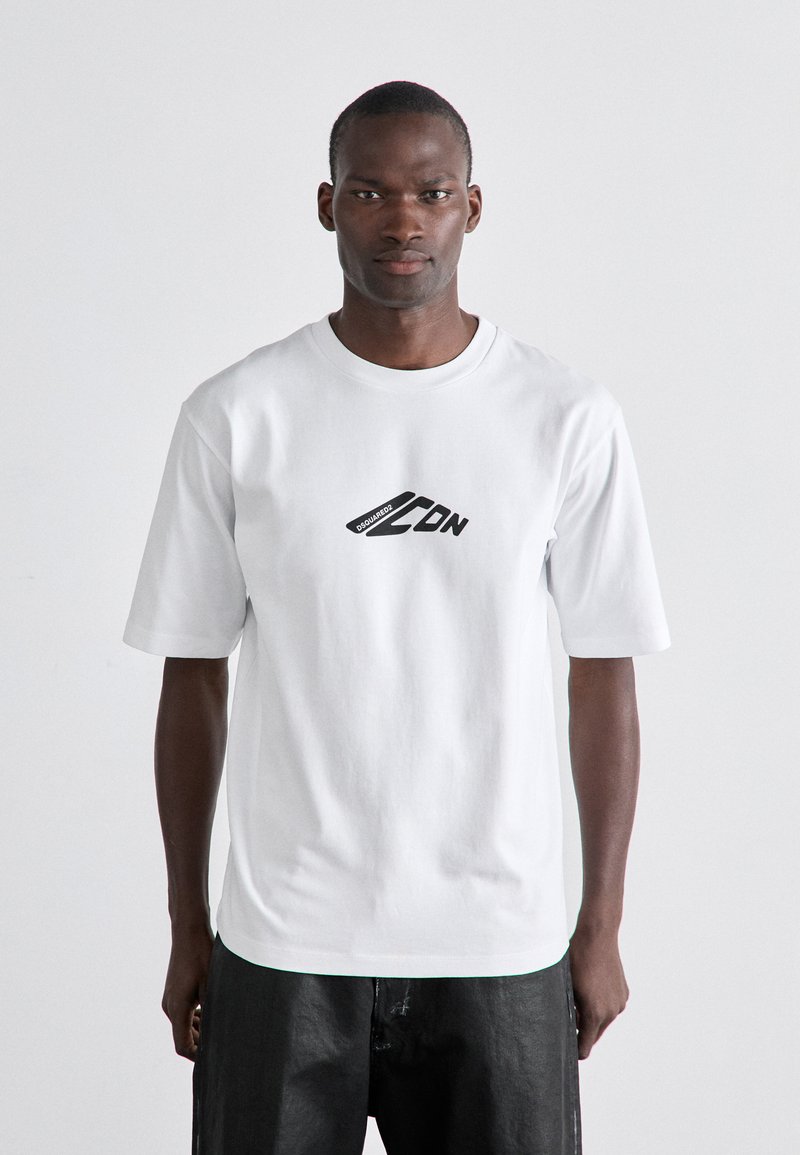 T-shirt en coton blanc à manches courtes, col rond, avec un logo graphique noir sur le devant. Texture lisse, coupe décontractée.