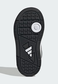 Crni gumeni đon tenisice s teksturiranim uzorkom za prianjanje, s bijelim okruglim naglaskom i dizajnerskim elementom od tri bijele pruge.