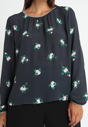 Langärmlige, dunkelgraue Bluse mit gerafftem Ausschnitt, die ein florales Muster in Pink und Grün sowie dezente Verzierungen aufweist.
