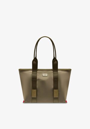 Sac fourre-tout taupe avec des poignées marron foncé et une petite étiquette rectangulaire sur le devant, avec des accents rouges aux coins inférieurs.