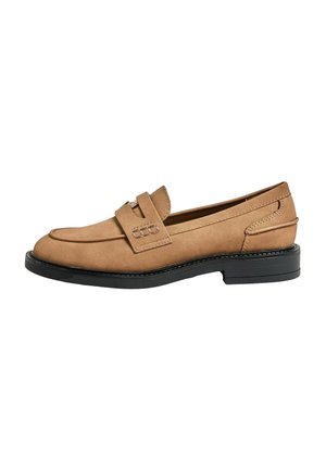 Mocasines de ante marrón con suela plana negra, punta redondeada y un detalle de correa en la parte superior. Costuras sutiles acentúan el diseño.
