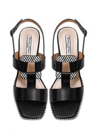 Sandali neri in pelle con una design a fascia larga, caratterizzati da un motivo a scacchi sulla parte superiore e una suola texture. Inclusa una fascia regolabile per la caviglia.