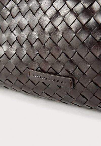 Καφέ πλεκτή δερμάτινη τσάντα με ορθογώνιο σχήμα και λεία υφή. Φέρει ετικέτα με λογότυπο και ανάγλυφο κείμενο.