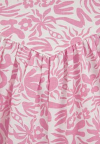 Viegls audums ar rozā ziedu rakstu, kas ietver dažādas formas un kontūras. Apkakles malā ir savirknētas krokas.