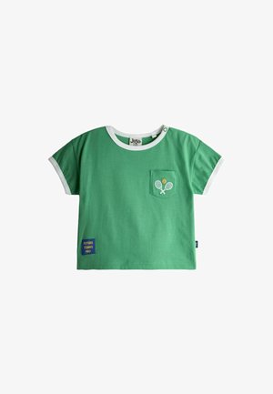 Grünes T-Shirt für Kleinkinder mit weißem Saum, kleiner Tasche mit gestickten Tennisschlägern und Ball sowie einem "Future Tennis Pro"-Aufnäher nahe dem Saum.