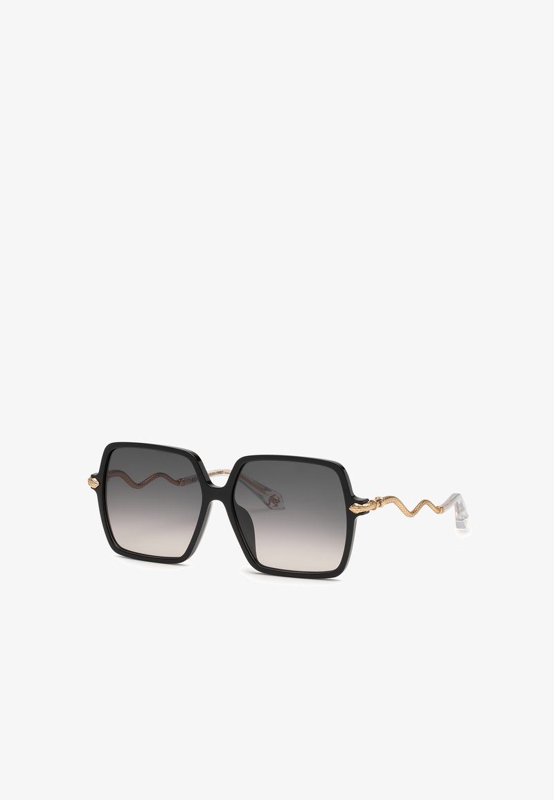 Lunettes de soleil carrées noires avec verres teintés dégradés et branches dorées à motif de serpent se terminant par des embouts en plastique transparent.