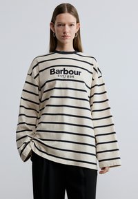 Langermad gestreept shirt in crème met zwarte strepen, voorzien van de tekst "Barbour EST.1894" aan de voorkant, gemaakt van zacht katoenen materiaal.
