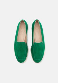Mocassini in suede verde con una superficie liscia, punta arrotondata e cuciture minimal, dotati di un interno soffice e un logo del marchio discreto.