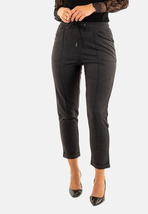 Pantalones gris oscuro de tejido texturizado, con cintura ajustable mediante cordón, bolsillos laterales y puños enrollados, combinados con tacones negros.