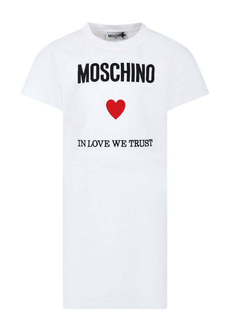 T-shirt bianca in cotone con maniche corte, decorata con il testo nero "MOSCHINO" e una grafica a cuore rossa sopra la scritta "IN LOVE WE TRUST" ricamata in nero.
