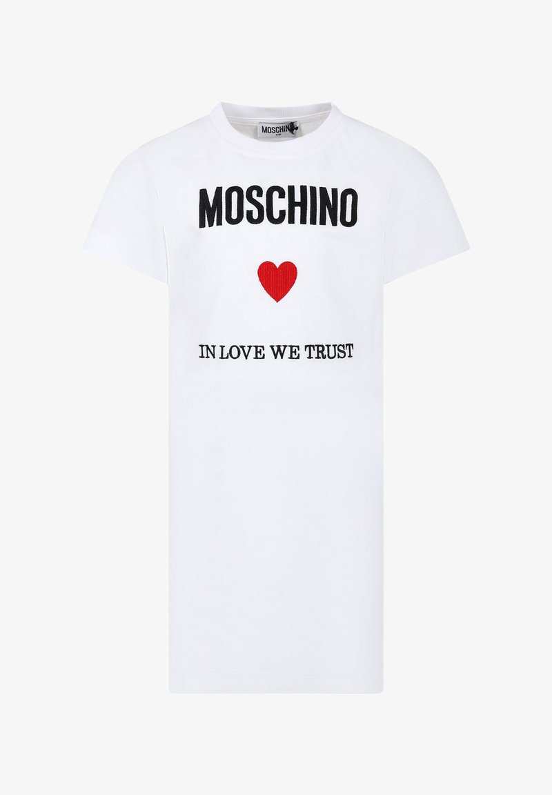T-shirt bianca in cotone con maniche corte, decorata con il testo nero "MOSCHINO" e una grafica a cuore rossa sopra la scritta "IN LOVE WE TRUST" ricamata in nero.