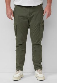 Cargo broeken gemaakt van olijfgroen stof, met zijzakken, een rechte snit en een lichtgewicht ontwerp, gecombineerd met witte sneakers.