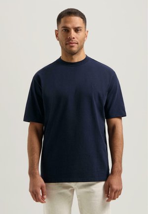 Navyblauwe t-shirt van zacht materiaal, met een ronde hals en korte mouwen, voorzien van een minimalistisch logo op de borst.