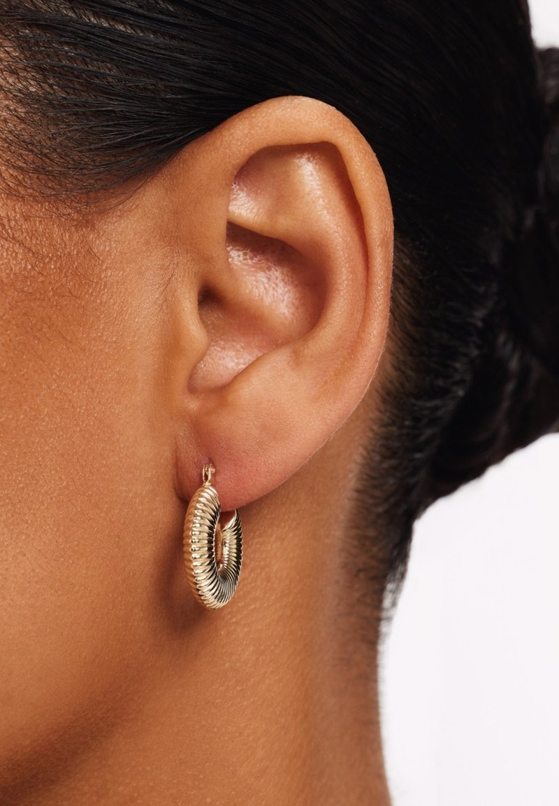 Oorringen in goudkleur met een geribbelde textuur en een spiraalvormig ontwerp. De oorringen zijn bevestigd aan een klein hefboomsluiting.