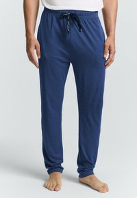 Un pantalon de lounge léger bleu marine avec une taille élastique, un cordon de serrage et des jambes fuselées, fabriqué en tissu doux.