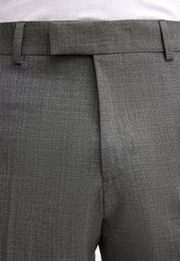 Pantaloni grigi su misura con un motivo a trama fine, caratterizzati da una parte anteriore piatta e una cintura con passanti, realizzati in tessuto leggero.