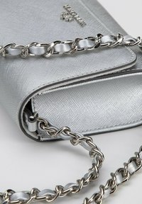 Sac à main synthétique argenté avec une finition texturée, doté d'une chaîne métallique et d'accents lisses contrastants le long des bords.