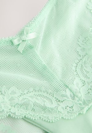 Mentola zaļas krāsas apakšveļa ar smalku mežģīņu apdari, tīkliņa tekstūru un mazu satīna loku uz kakla izgriezuma.