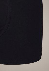 Czarne bokserki bawełniane o gładkiej fakturze, z dopasowanym krojem i elastycznym pasem. Bezszwowa konstrukcja zwiększa komfort.