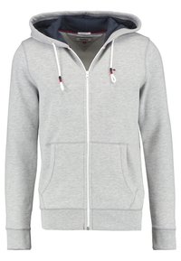 Haut de sweat à capuche zippé gris clair avec poches avant, cordons blancs avec des accents rouges et navy, et doublure intérieure de la capuche marine.